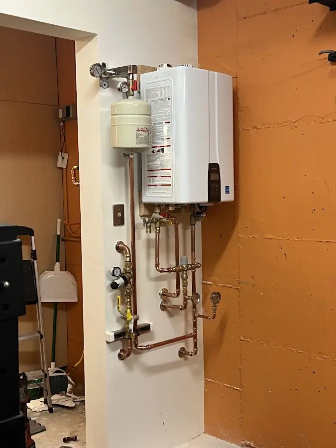 Plumbing technician inspecting water heater connections in Milbank
